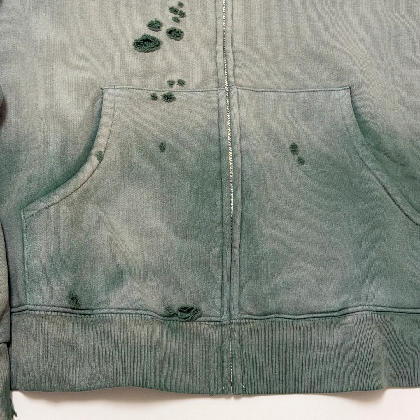 More details SAINT Mxxxxxx DBL FACE ZIP UP HOODIE/GREEN Double-layer damaged waffle zipper jacket, washed green S-XL, a style that has been used in the summer. After continuous fine polishing, it is finally shipped. The finished product is simply a work of art. Super heavy washing and distressing. Multiple horse water fading. Many hand-made wormhole damage processing. Deconstruction and reorganization embroidery technology. Customized zipper with LOGO. The color details of the zipper webbing are also correct. Original grade fruit main label and wash water label. Top purchasing grade. A layer of waffle fabric is added to the inner lining to make the overall texture stronger and increase the comfort and warmth of the wearer.